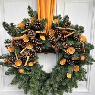 Large_wreath_with_cinnamon_and _dried_orange_slices_and_a_large_ribbon