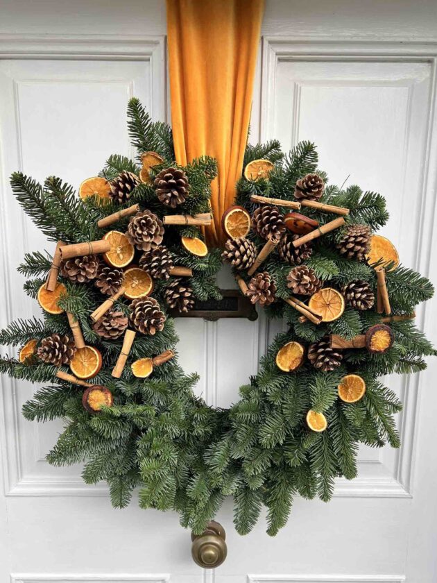 Large_wreath_with_cinnamon_and _dried_orange_slices_and_a_large_ribbon
